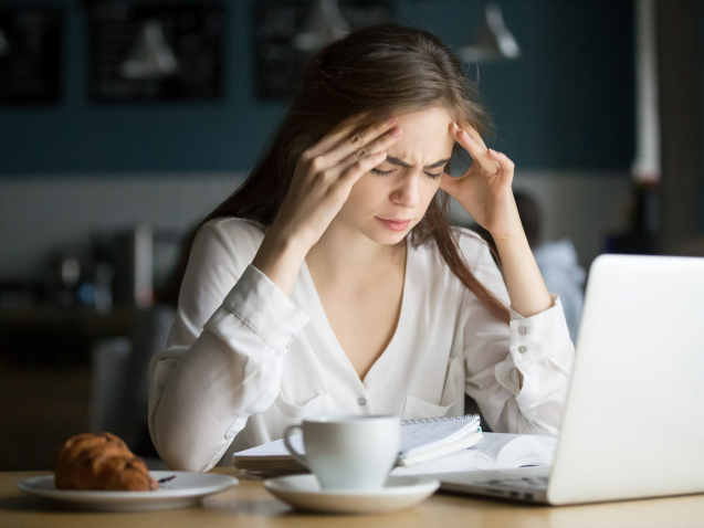 Nervous stressed woman feeling anxiety or strong headache massaging temples studying in cafe, young tired female student experiencing panic attack preparing for test or exam in public place